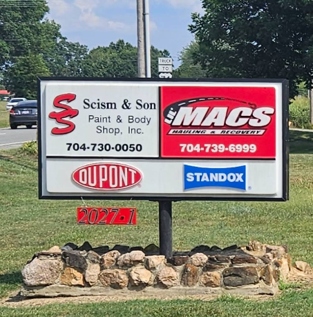 Scism & Son Paint & Body Shop road sign with phone number 704-730-0050
